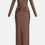 Woman wearing brown long-sleeve maxi dress with ruched waist belt and gold clutch — Lediel | Endless UAE