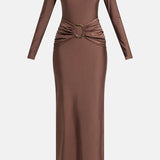 Woman wearing brown long-sleeve maxi dress with ruched waist belt and gold clutch — Lediel | Endless UAE