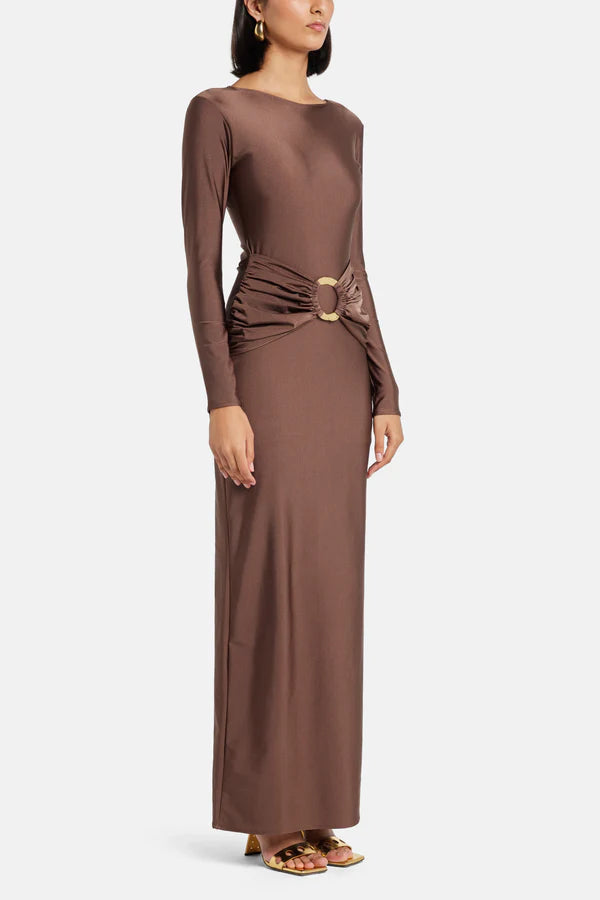 Woman wearing brown long-sleeve maxi dress with ruched waist belt and gold clutch — Lediel | Endless UAE