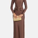 Woman wearing brown long-sleeve maxi dress with ruched waist belt and gold clutch — Lediel | Endless UAE
