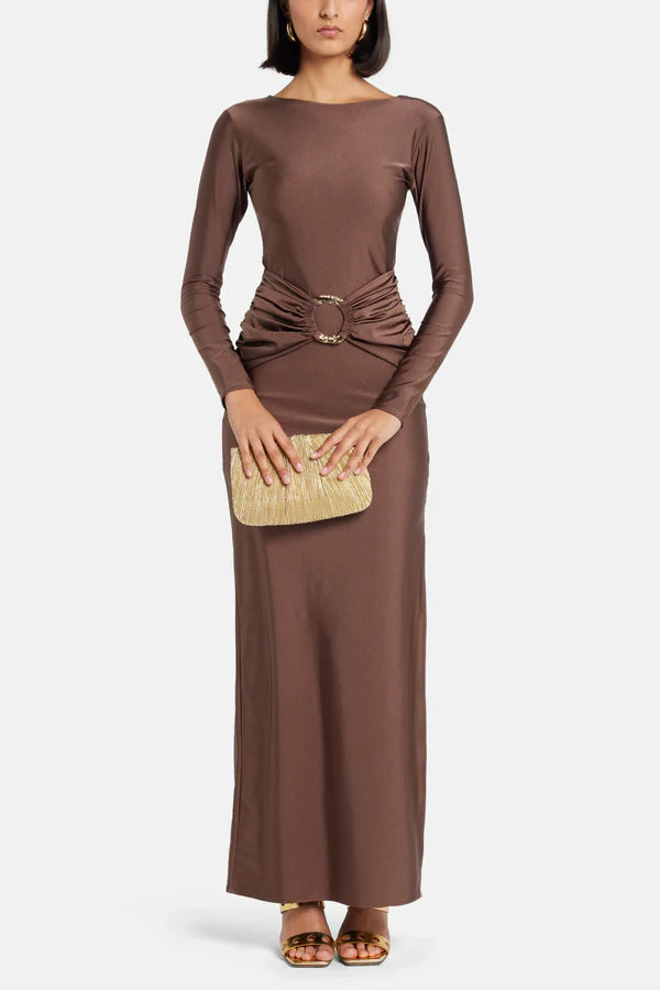 Woman wearing brown long-sleeve maxi dress with ruched waist belt and gold clutch — Lediel | Endless UAE
