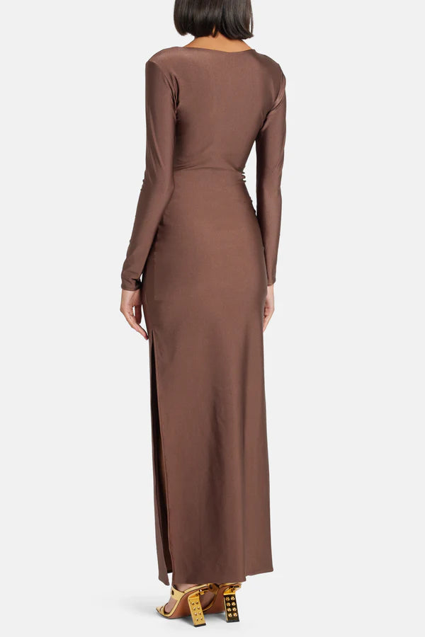 Woman wearing brown long-sleeve maxi dress with ruched waist belt and gold clutch — Lediel | Endless UAE