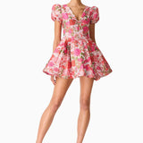 Woman wearing pink floral mini dress with short puffed sleeves and tie-front neckline — Elliatt | Endless UAE