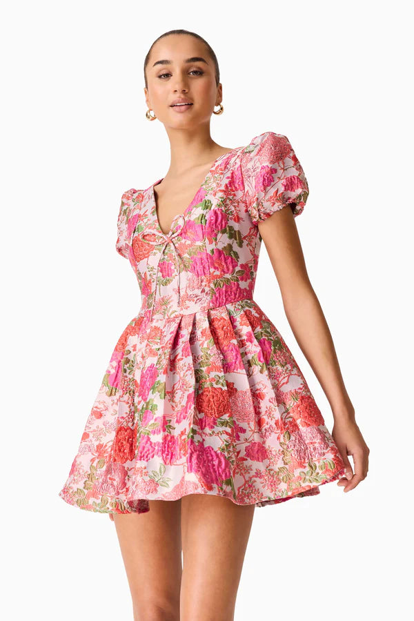 Woman wearing pink floral mini dress with short puffed sleeves and tie-front neckline — Elliatt | Endless UAE