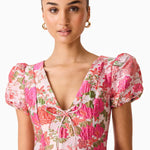 Woman wearing pink floral mini dress with short puffed sleeves and tie-front neckline — Elliatt | Endless UAE