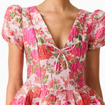 Woman wearing pink floral mini dress with short puffed sleeves and tie-front neckline — Elliatt | Endless UAE