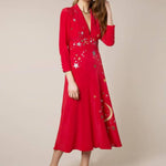 Woman wearing red midi wrap dress with gold and silver star embroidery, styled with white slip-on shoes — RIXO | Endless UAE