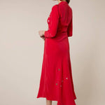 Woman wearing red midi wrap dress with gold and silver star embroidery, styled with white slip-on shoes — RIXO | Endless UAE