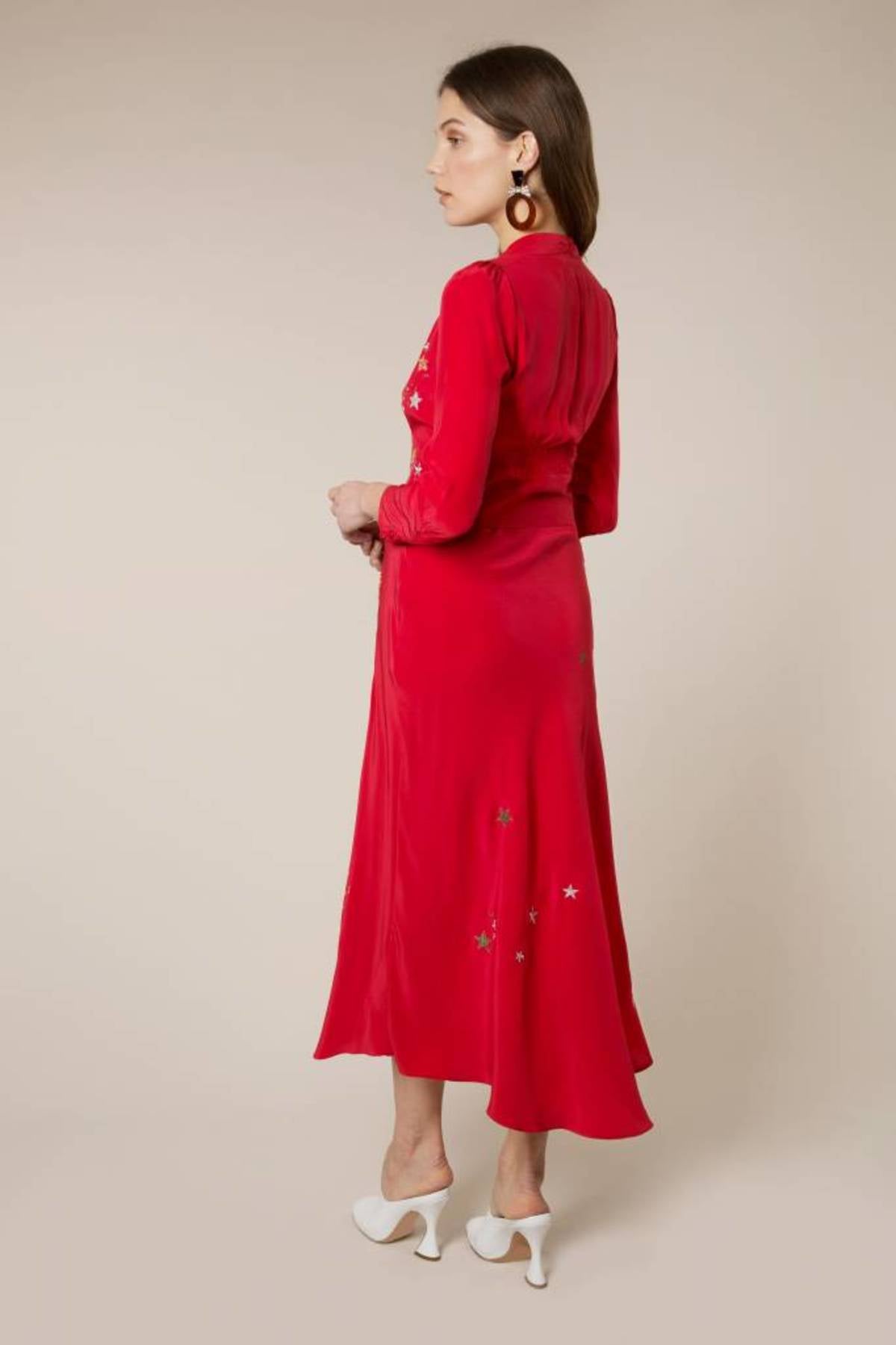 Woman wearing red midi wrap dress with gold and silver star embroidery, styled with white slip-on shoes — RIXO | Endless UAE