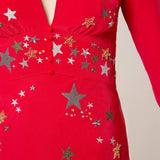 Woman wearing red midi wrap dress with gold and silver star embroidery, styled with white slip-on shoes — RIXO | Endless UAE