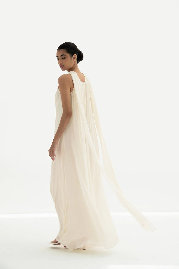 Elegant cream sleeveless maxi dress with flowing pleated cape back detail and floor-length silhouette — Nora The Label | Endless UAE