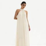 Elegant cream halter neck maxi dress with flowing silhouette and gathered neckline detail — Nora The Label | Endless UAE