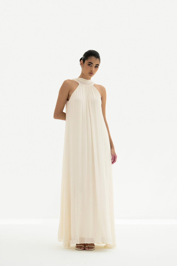Elegant cream halter neck maxi dress with flowing silhouette and gathered neckline detail — Nora The Label | Endless UAE