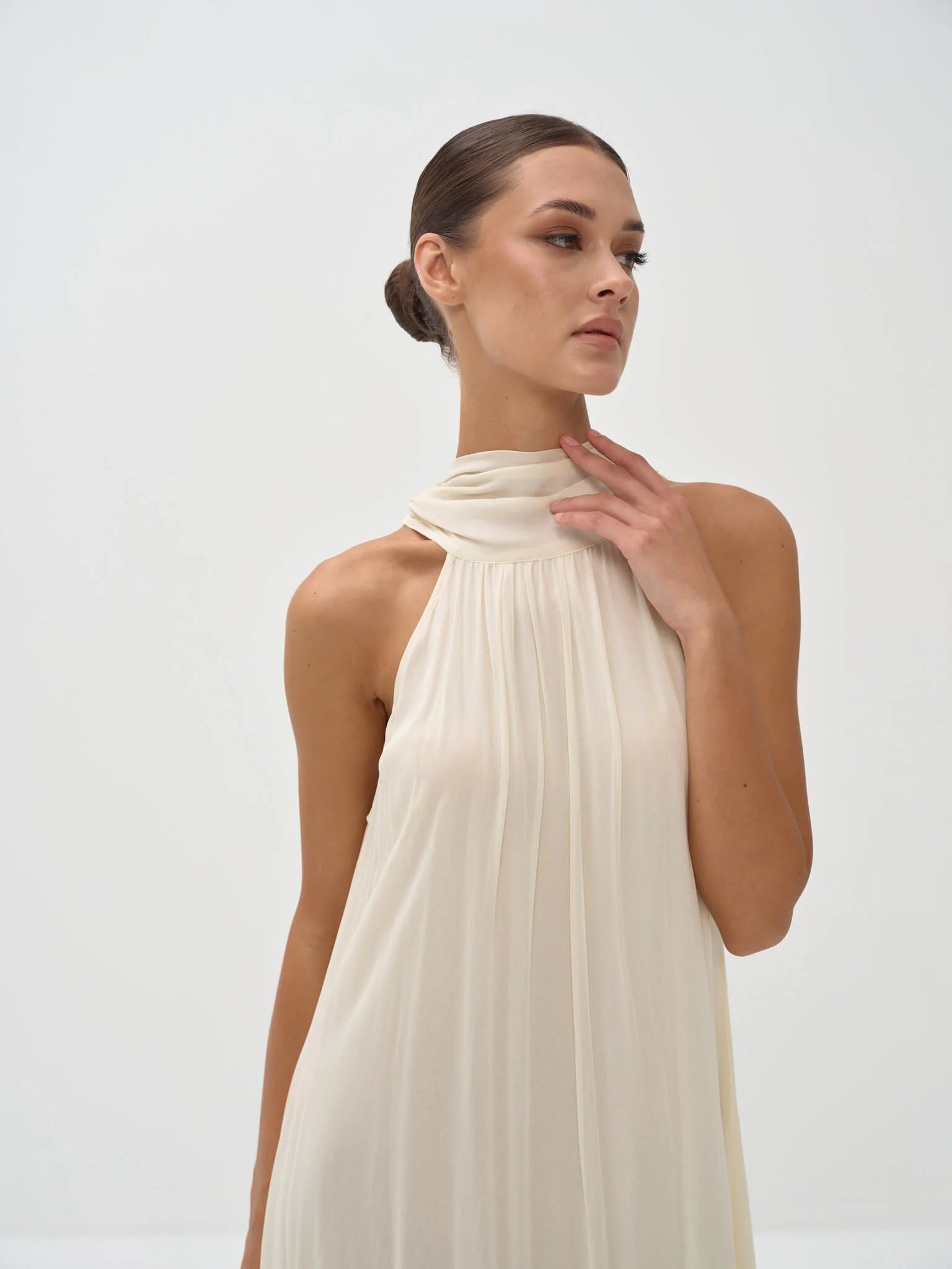 Elegant cream halter neck maxi dress with draped neckline and flowing silhouette — Nora The Label | Endless UAE