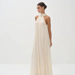 Elegant cream halter neck maxi dress with flowing pleated fabric and floor-length silhouette — Nora The Label | Endless UAE