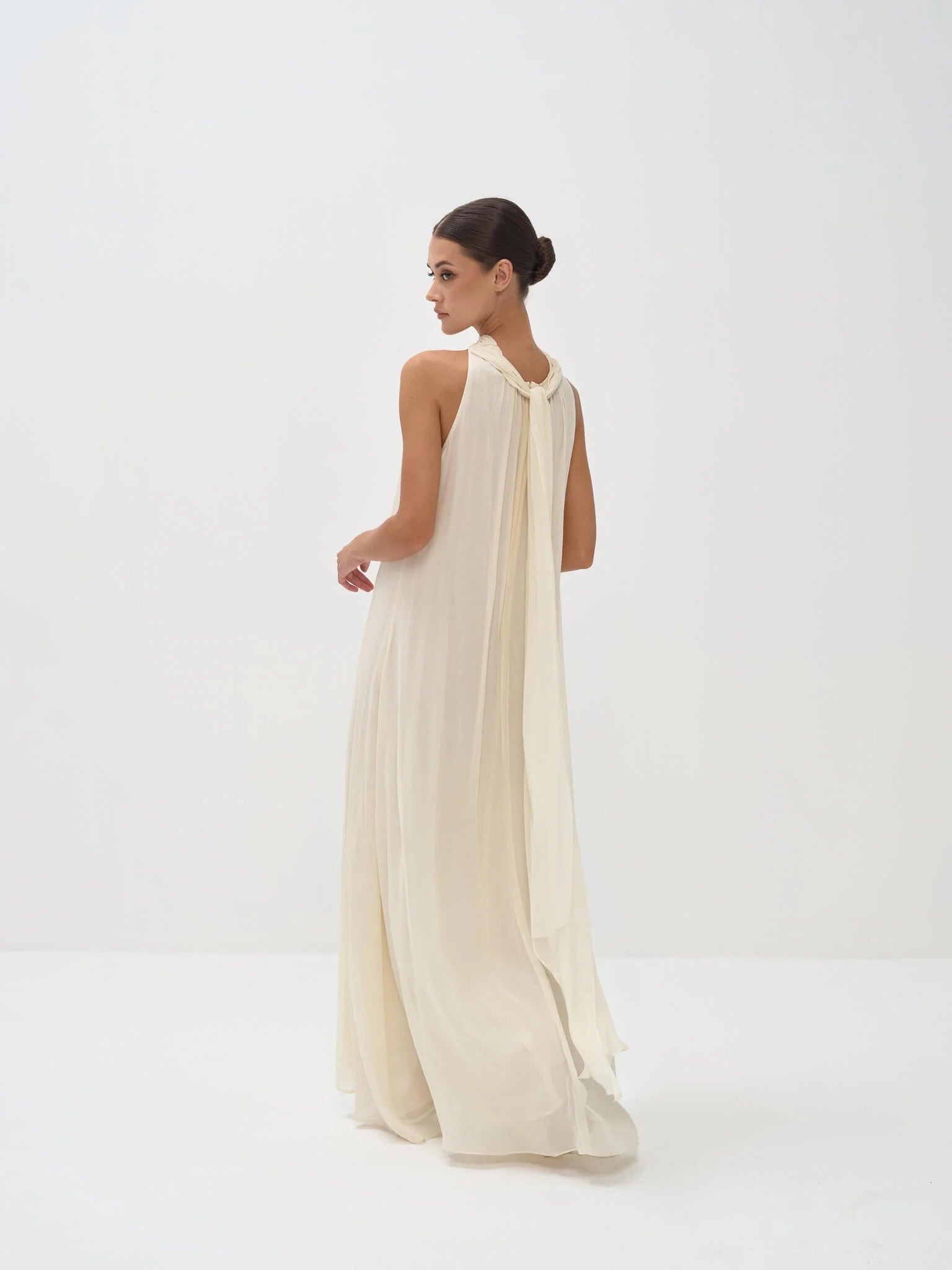 Elegant cream halter neck maxi dress with flowing silhouette and floor-length hem — Nora The Label | Endless UAE