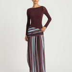 Woman wearing burgundy long sleeve maxi dress with striped skirt detail — BENNI. | Endless UAE