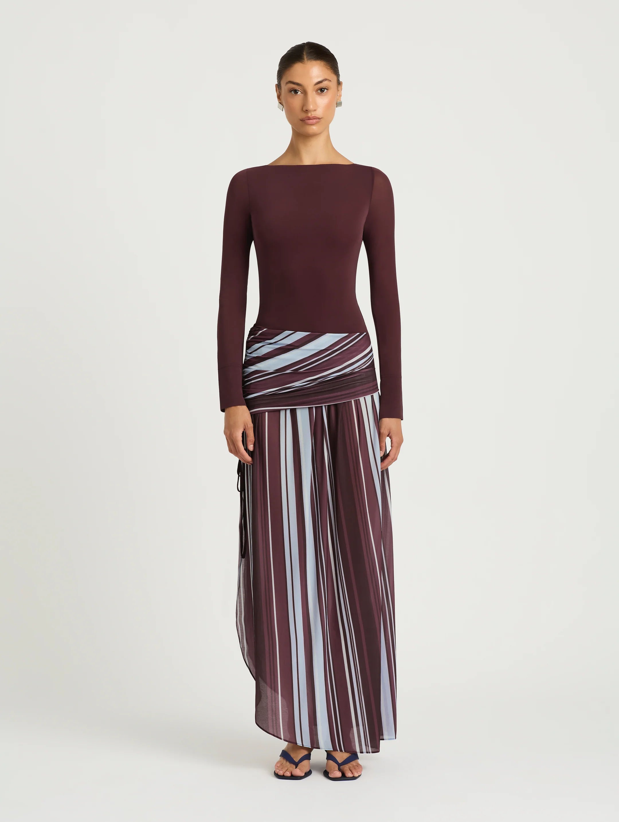 Woman wearing burgundy long sleeve maxi dress with striped skirt detail — BENNI. | Endless UAE