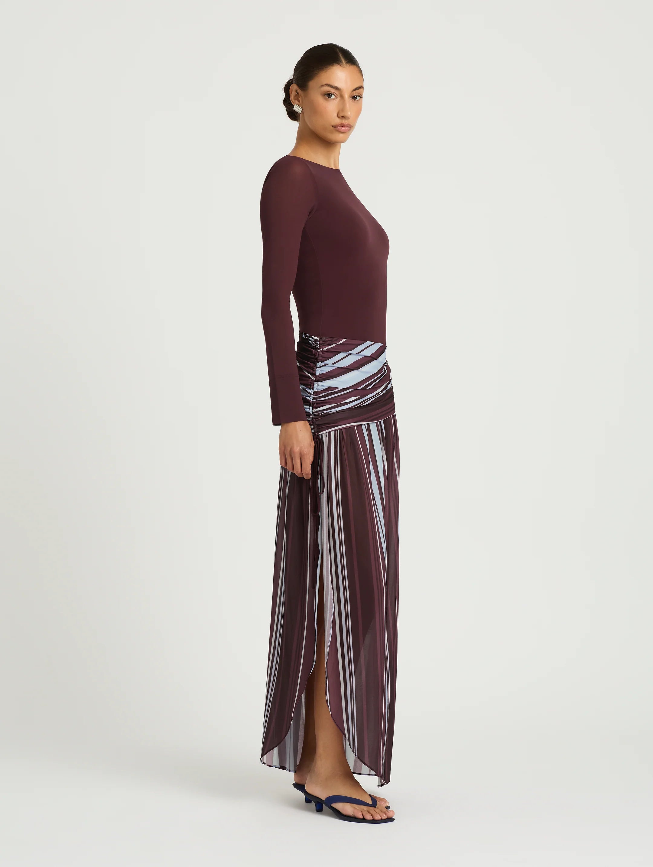 Woman wearing burgundy long sleeve maxi dress with striped skirt detail — BENNI. | Endless UAE