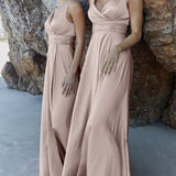 Two models wearing elegant blush pink floor-length bridesmaid dresses with wrap bodices and flowing skirts against rocky backdrop — You&I Bridal | Endless UAE
