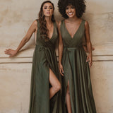 Two women wearing olive green wrap bridesmaid dresses with flowing skirts against a neutral background — You&I Bridal | Endless UAE