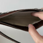Dark brown croc-embossed mini shoulder bag with chain detail held in hand — By Far | Endless UAE