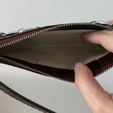 Dark brown croc-embossed mini shoulder bag with chain detail held in hand — By Far | Endless UAE