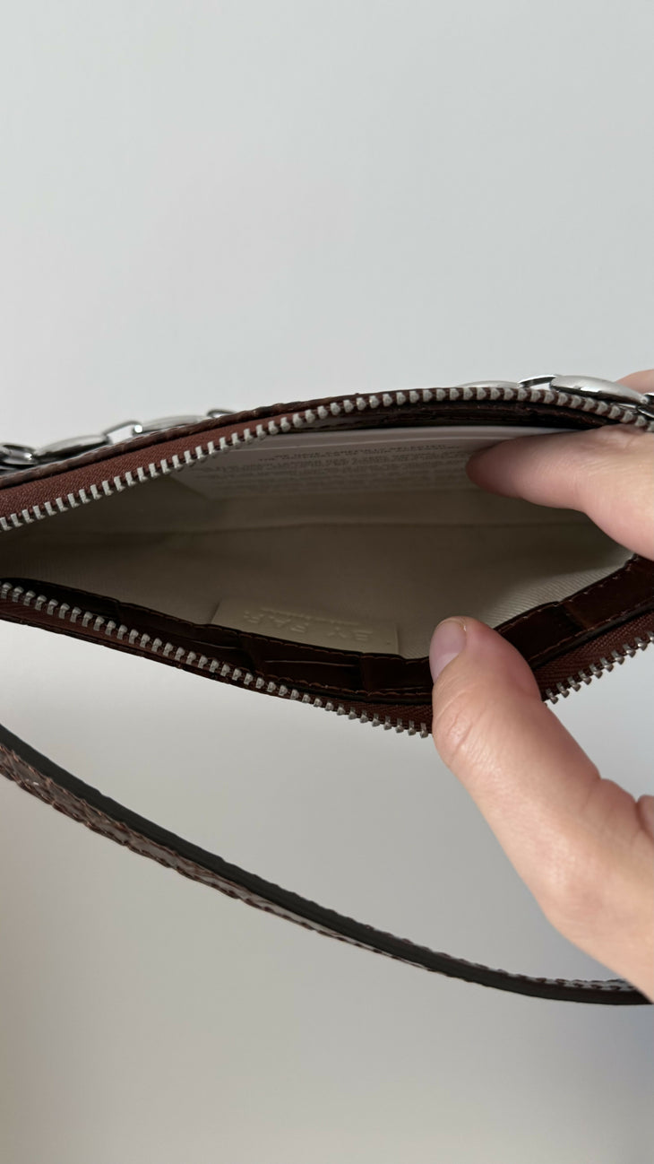 Dark brown croc-embossed mini shoulder bag with chain detail held in hand — By Far | Endless UAE