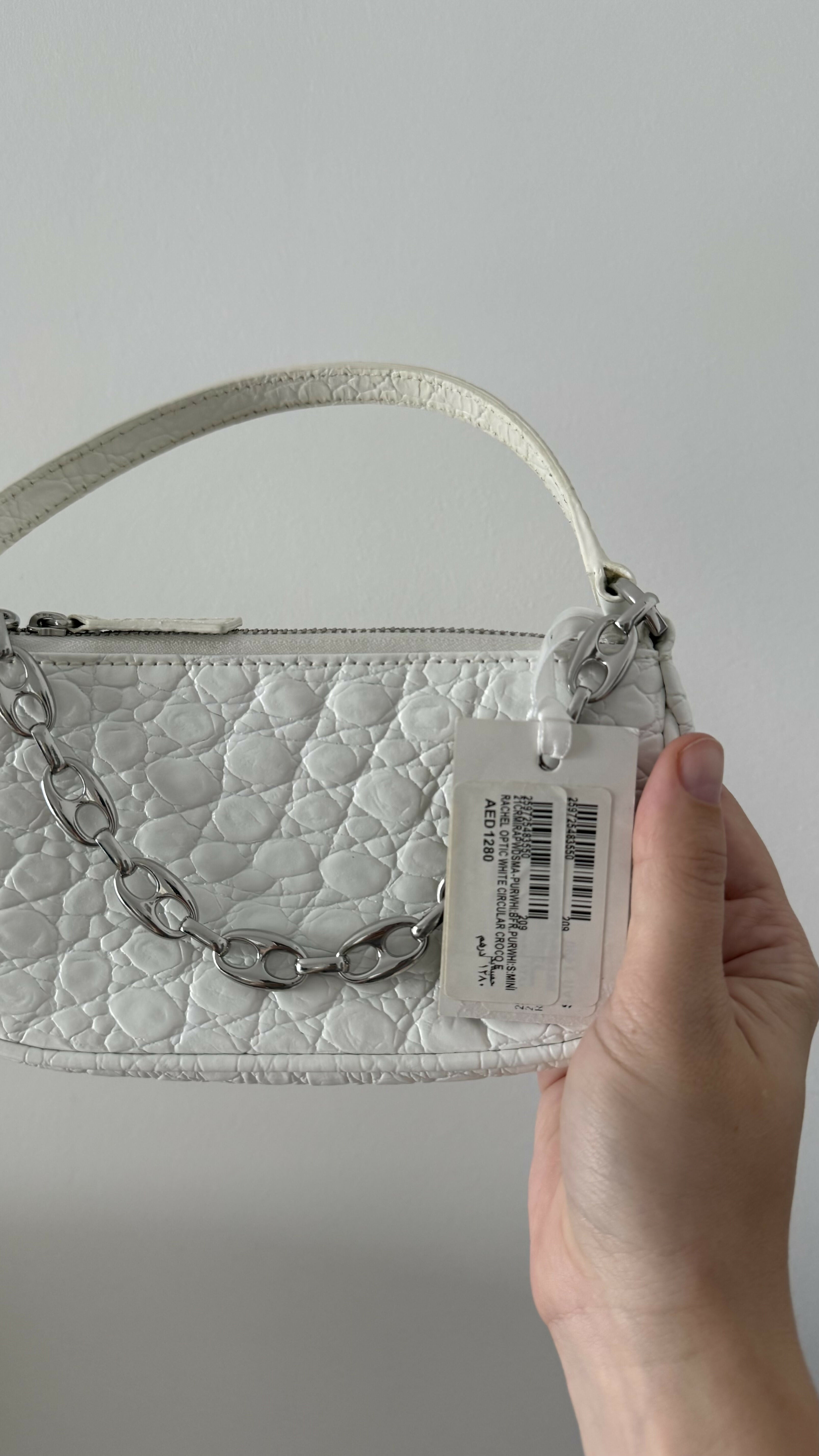 White quilted mini shoulder bag with silver hardware held up against neutral background — By Far | Endless UAE