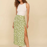 Woman wearing white sleeveless tank top and green floral midi skirt with side slit — Endless | Endless UAE