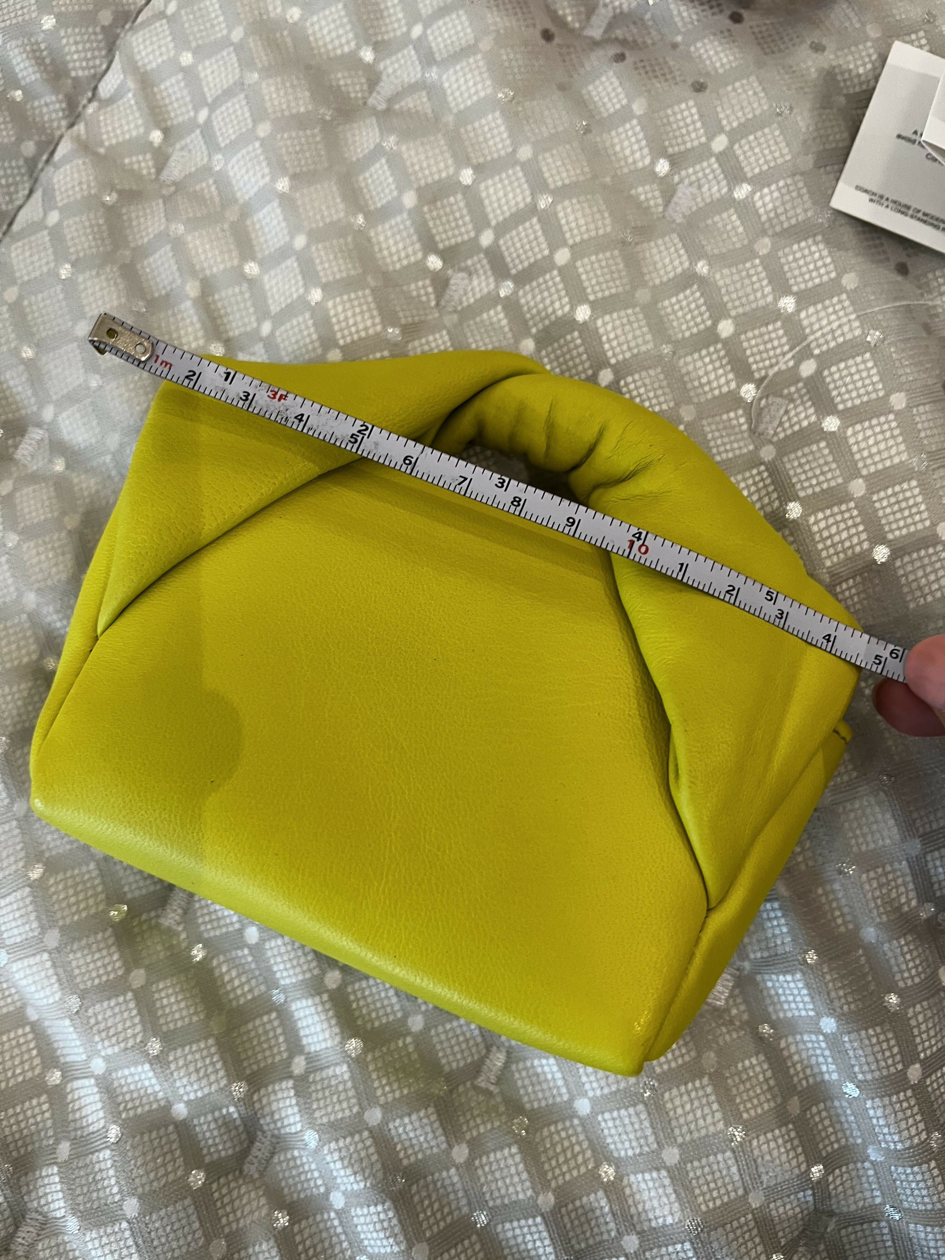Yellow leather Twister Nano crossbody bag being measured with ruler showing compact size — JW Anderson | Endless UAE
