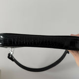 Black crocodile embossed leather shoulder bag held in hand against white background — By Far | Endless UAE