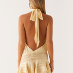 Butter yellow halter neck mini dress with open back, tie detail and ruffled skirt hem — Peppermayo | Endless UAE