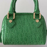 Green crocodile-embossed mini tote bag with gold hardware held by hand — By Far | Endless UAE
