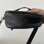 Black leather mini shoulder bag with textured finish held open to show interior — By Far | Endless UAE