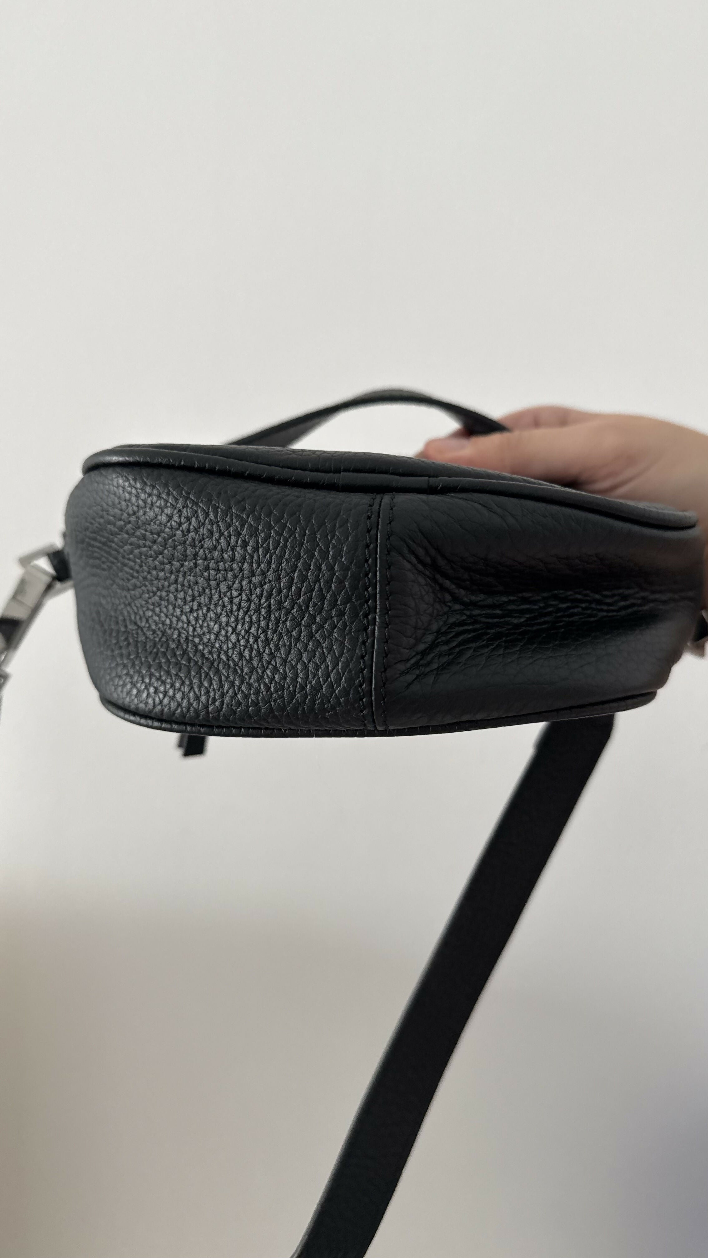 Black leather mini shoulder bag with textured finish held open to show interior — By Far | Endless UAE