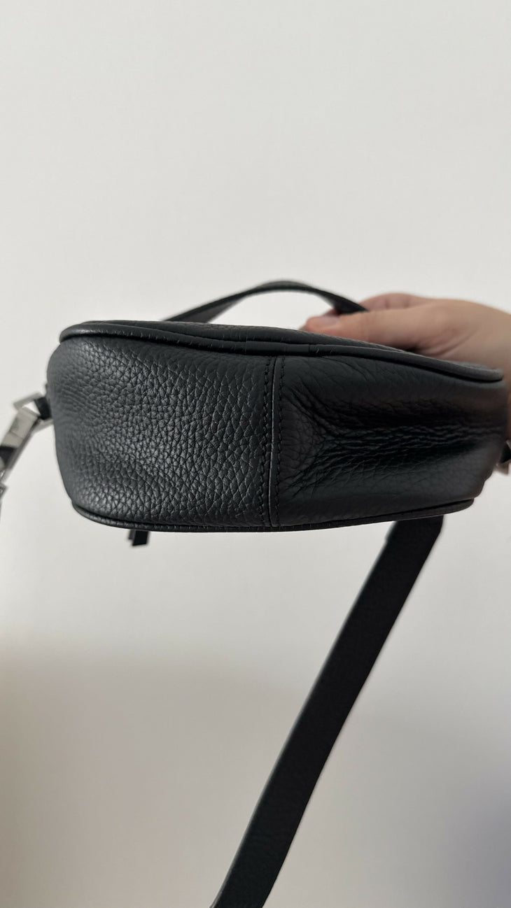 Black leather mini shoulder bag with textured finish held open to show interior — By Far | Endless UAE