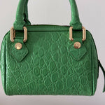 Green crocodile-embossed mini tote bag with gold hardware held by hand — By Far | Endless UAE