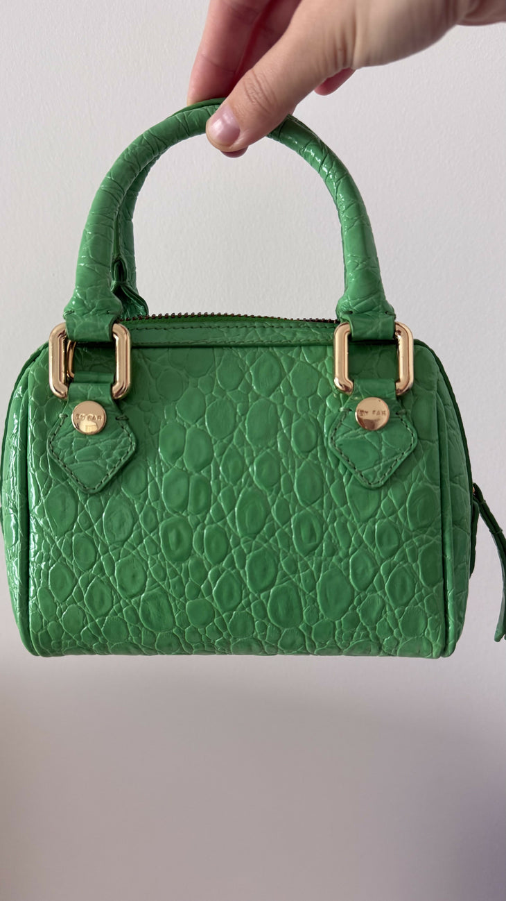 Green crocodile-embossed mini tote bag with gold hardware held by hand — By Far | Endless UAE