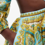 Vibrant paisley printed midi dress with tie-front detail and puff sleeves in turquoise and gold tones — Zimmermann | Endless UAE