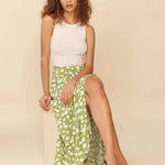 Woman wearing white sleeveless tank top and green floral midi skirt with side slit — Endless | Endless UAE
