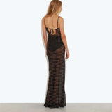 Back view of woman wearing black sheer polka dot maxi dress with tie detail and spaghetti straps — Rat & Boa | Endless UAE