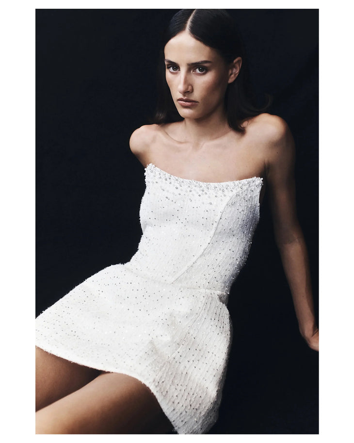 Woman wearing white strapless tweed corset mini dress against black background — Meshki | Endless UAE