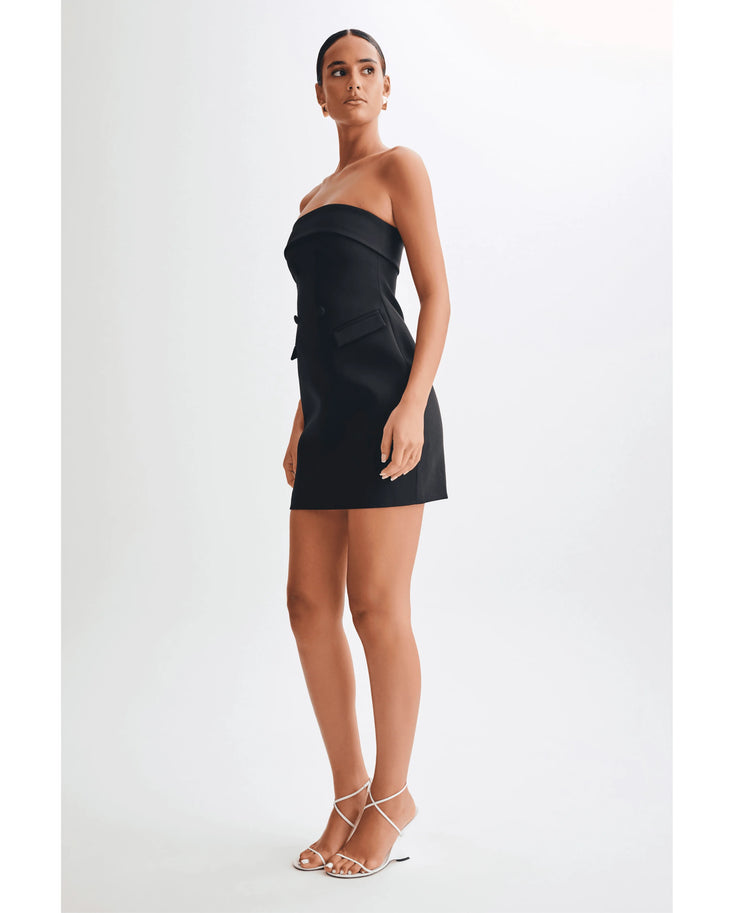 Strapless black mini dress with tailored suiting details and side pockets, paired with white strappy heels — Meshki | Endless UAE
