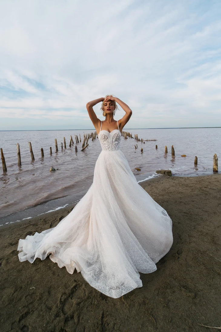 Ethereal A-line wedding dress with sweetheart neckline and flowing tulle skirt on beach — Romanova Atelier | Endless UAE