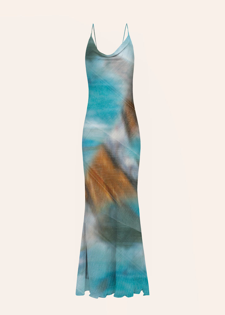 Woman wearing blue tie-dye maxi dress standing on rocky beach — Dvete | Endless UAE