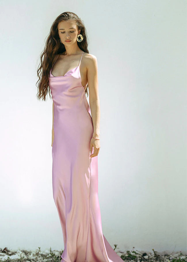 Woman wearing a pink satin slip dress with thin straps and flowing maxi length — Dvete | Endless UAE