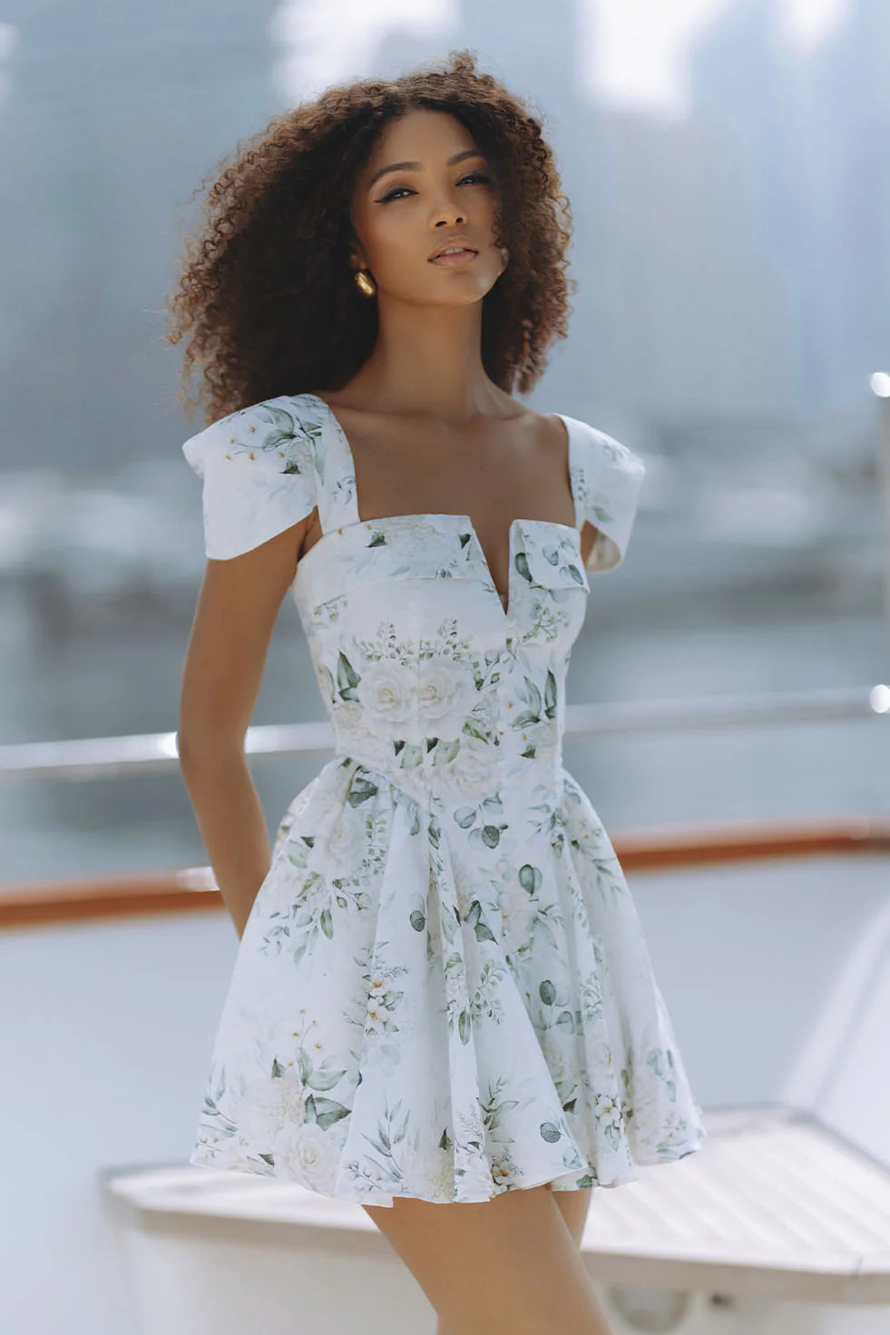 Woman wearing white floral mini dress with puff sleeves on balcony — Chic Le Frique | Endless UAE