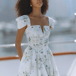 Woman wearing white floral mini dress with puff sleeves on balcony — Chic Le Frique | Endless UAE