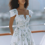 Woman wearing white floral mini dress with puff sleeves on balcony — Chic Le Frique | Endless UAE